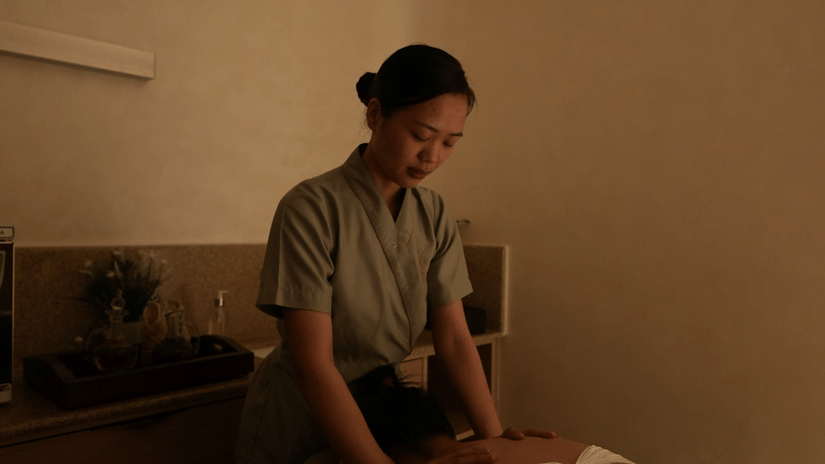 A woman providing a shoulder massage service in a spa at Karma Lakelands