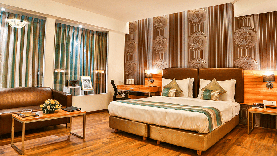 Club Room at T24 Residency, Andheri East (Terminal 2) featuring a double bed in warm lighting with a work desk beside the lamp on the nightstand