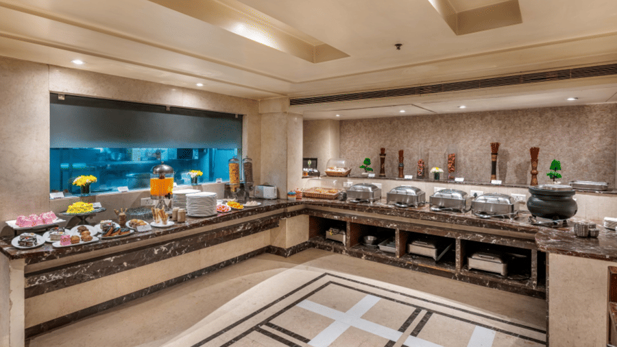 a breakfast buffet counter at Libra Lords Inn Jaipur with cereals, confectionaries and neatly arranged white ceramics