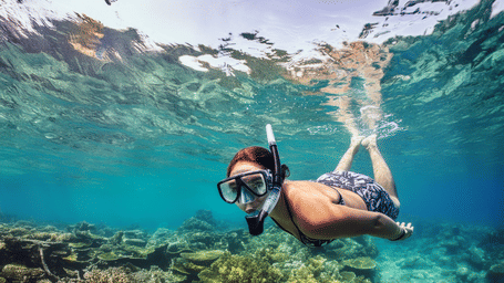 A woman snorkeling in Antigua underwater with coral reefs nearby, in seas near the Tamarind Hills Resort and Villas