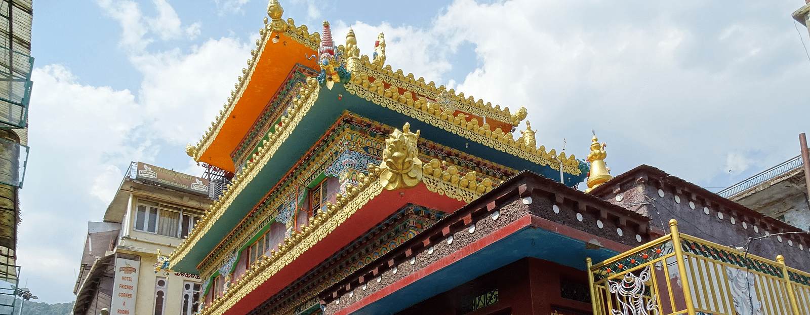 An image of a monastery near a road where people are seen walking