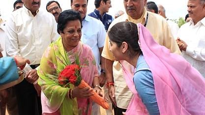 A woman receiving a bouquet from another woman during a daytime event