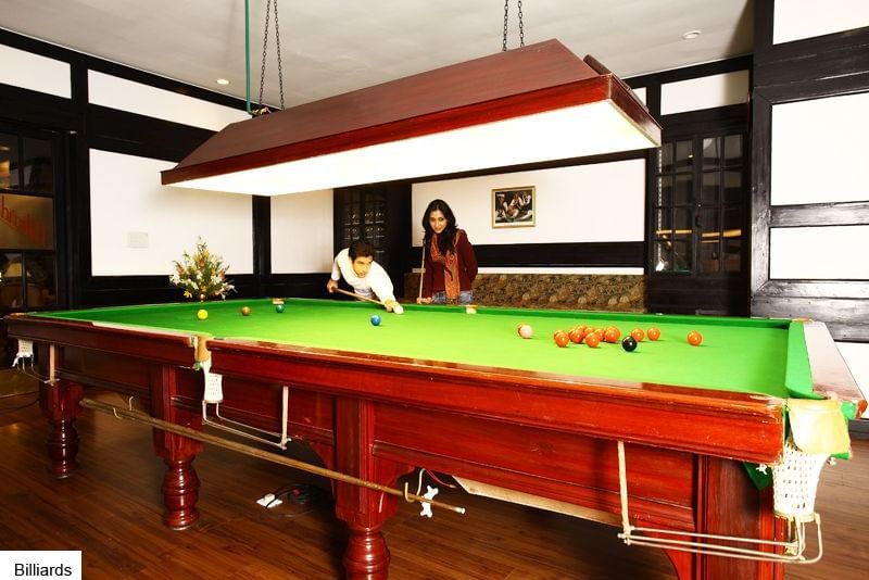 A couple playing snooker at The Retreat Hotel and Convention Centre's indoor games section