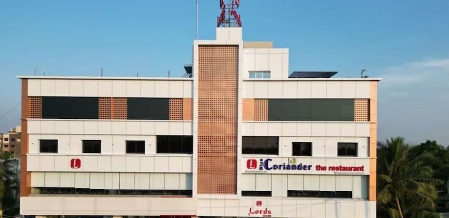 The image shows a multi-story building with signage indicating Coriander the restaurant and Lords at the entrance - Lords Eco Inn Navsari.