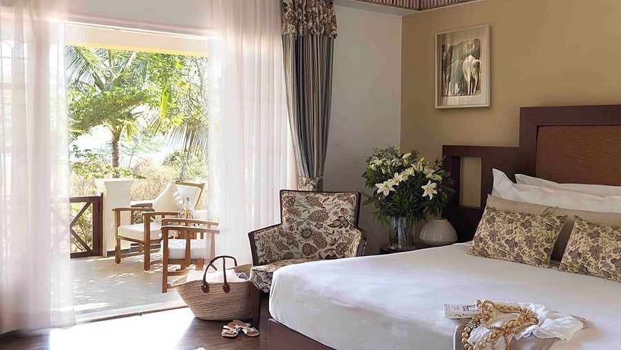 bedroom and balcony in the Waterfront Verandah Room at The Serai Kabini
