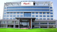 Daspalla Hotel exterior with glass facade white building green lawn and welcoming entrance staff standing at the front door