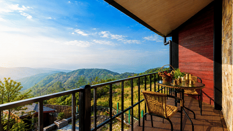 A room with a balcony featuring chairs, a table, and sky in the front. | Polo Resort, Cherrapunji