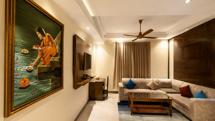 Executive Room with Living Area featuring a sofa, framed artwork and warm lighting at Eastlynn Resort, Rishikesh.