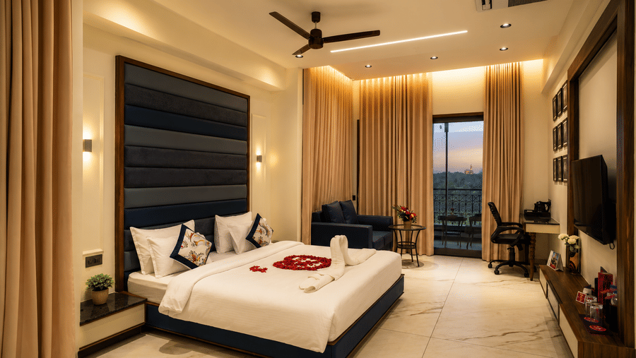 Suite Room at Lords Swastik Studio, Kodinar with a spacious king bedroom, seating area, work desk, balcony access, and elegant interiors.