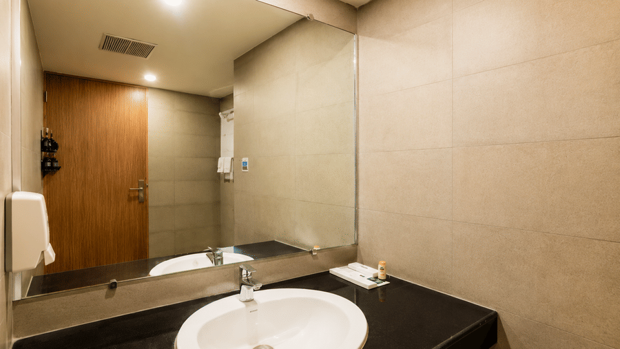 Modern bathroom with a vanity and wash basin at Max Hotel Jabalpur.