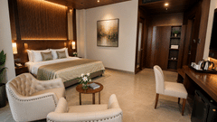 A bedroom featuring a king size bed, 2 armchairs, and a writing desk at Ananta Express, Jaunpur.