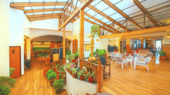 A pathway filled with flower pots leading to a well furnished Sunset Bar and Lounge featuring several tea table and chairs and spread across the dining space at Central Heritage Resort and Spa