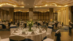 The banquet hall with multiple round tables set for an event at Riviera Sarovar Portico, Pathankot.