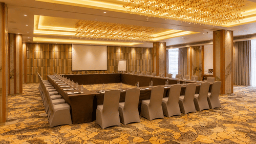 A spacious conference room is perfectly arranged with chairs and a screen - Pride Elite Himmatnagar, Gujarat