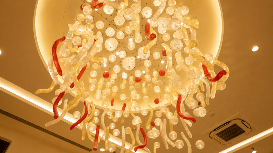 Close up view of a decorative chandelier installation inside the banquet hall at Ambrosia Sarovar Portico, Haridwar.