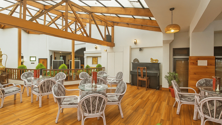 Sunset Bar and Lounge at Central Heritage Resort and Spa, Darjeeling featuring several sets of table and chairs