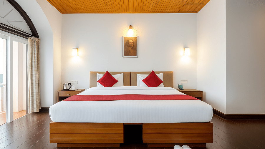 Wide angle view of a room at Central Hotels showing two beds with red and white bedding wooden ceiling vaulted arch white walls and warm wall lamps on both sides.