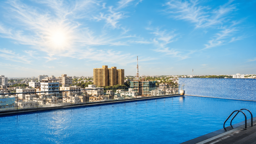 rooftop infinity pool overlooking a coastal city skyline under a bright, sunny sky. This type of architectural feature is commonly found at high-end hotels and luxury residential complexes in Golden Tulip, Lucknow .