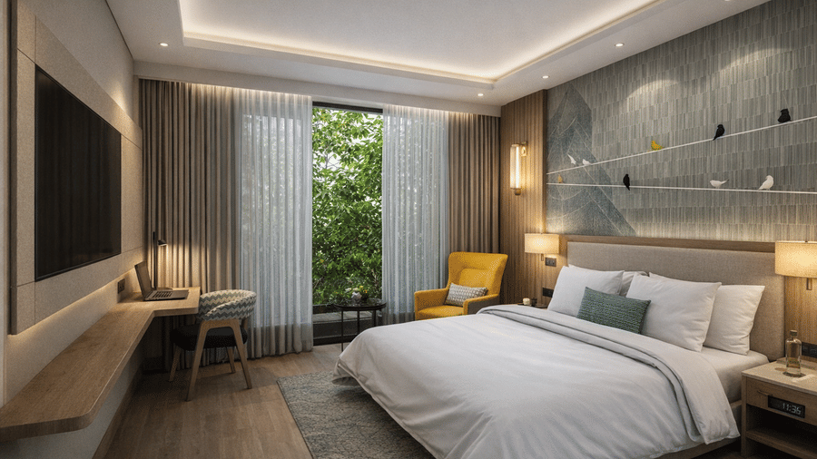 A Deluxe King Room at KPG Sarovar Portico, Raj Nagar Extension, Ghaziabad, with a king size bed, an armchair, and a decorative wall panel depicting birds on a wire.