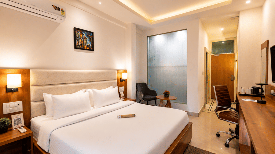 Spacious deluxe room with warm lighting and modern décor at Pride Ashiyana Resort Mussoorie.