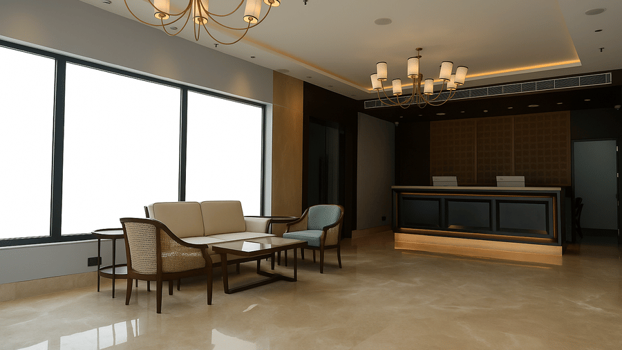 A well-lit hotel lobby features comfortable seating arrangements, a large window, and a chandelier | Sarovar Portico, Hanumangarh