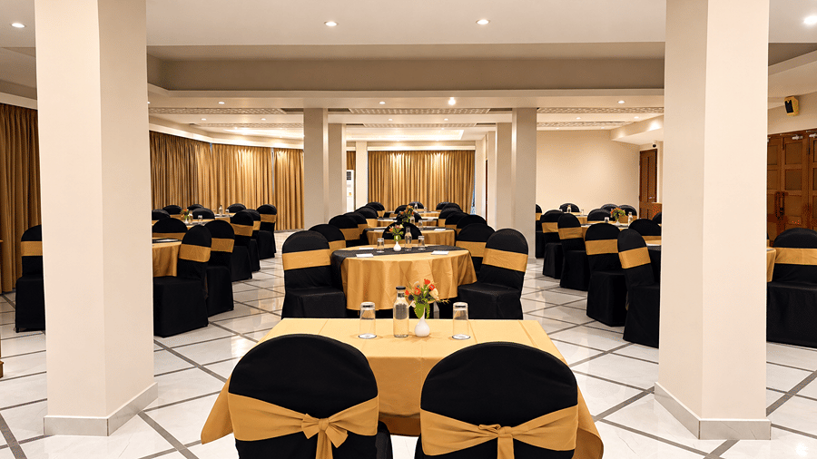 Sapphire Banquet Hall at Silver Sand Sentinel, Port Blair, featuring multiple round tables with table settings, floral centrepieces, banquet seating, and a spacious tiled floor.