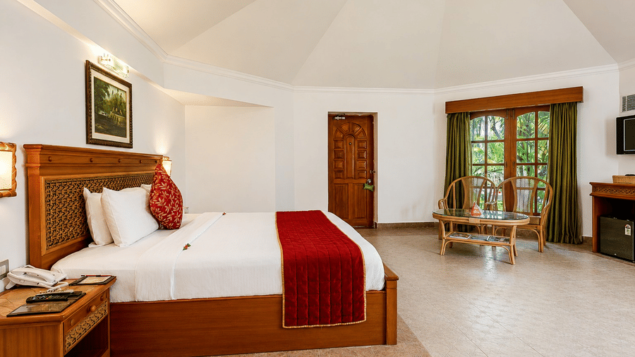 Poolside Room with a king bed, red accents, and warm wooden furnishings at Chariot Beach Resorts, offering a relaxing and comfortable retreat