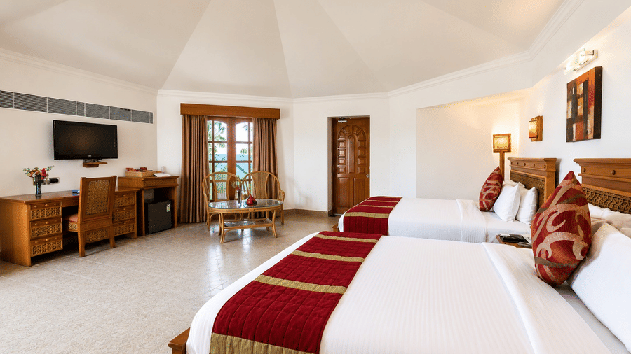 Poolside Room with twin beds, red and gold accents, and a cozy seating area at Chariot Beach Resorts, offering a comfortable and relaxing stay