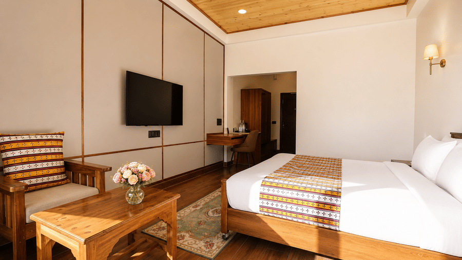 Premium Room with Balcony at Summit Rungkhung Village Resort - The Signature Collection showing a double bed, bedside lamps, coffee table, seating, wall-mounted television, and floor rug.