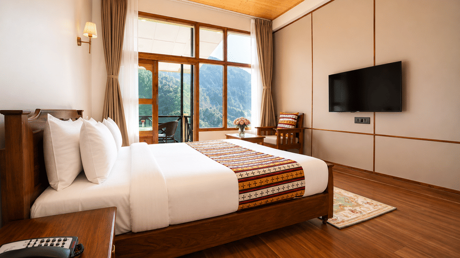 Premium Room with Balcony  at Summit Rungkhung Village Resort - The Signature Collection with a double bed, bedside tables, wall-mounted television, armchair, curtains, and floor-to-ceiling glass doors opening to a balcony.