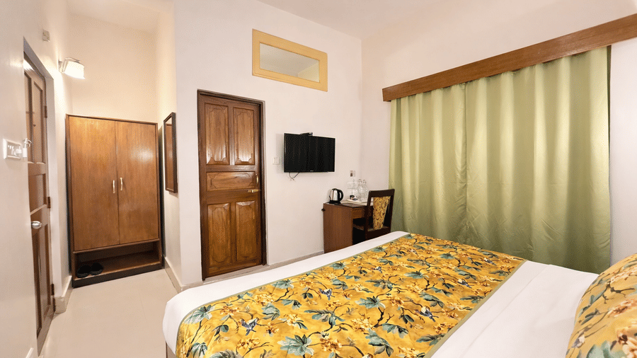 Standard Room at Summit Ttakshang Residency Hotel and Spa, Gangtok featuring a bed, wardrobe, flat TV screen, a work desk and chair, and a tea and coffee maker.
