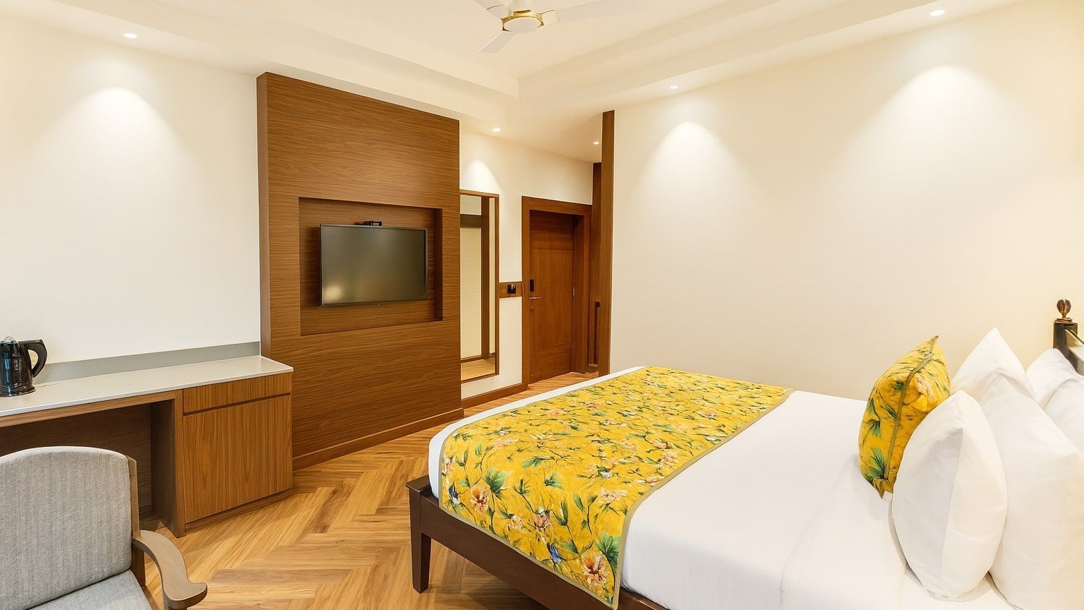 Premium Ganges View Room with Bathtub  at Summit by the Ganges Beach Resort and Spa, Rishikesh featuring a bed, a chair, a table, and a flat TV screen.