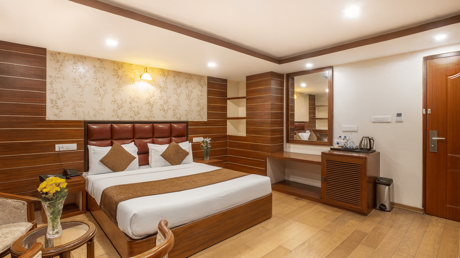 Room interior with seating area and double bed at Yashshree Jai Hotel & Banquet, Darjeeling.