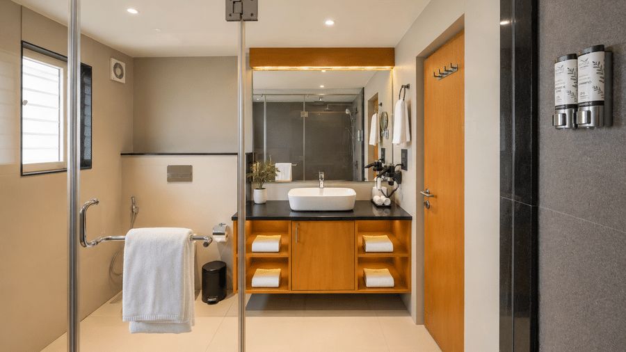 A contemporary glass-enclosed bathroom with a stylish vanity counter at BluSalzz Collection - Casa Onze, Arpora.