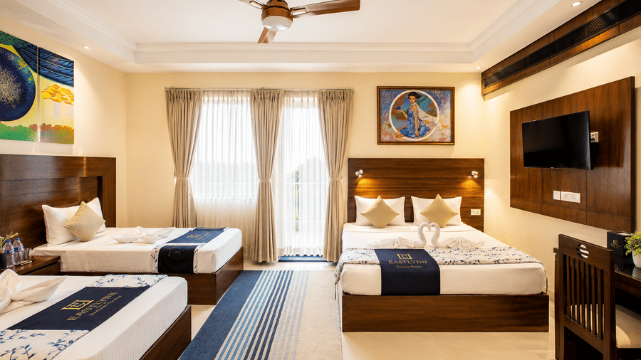 Family Room with Balcony featuring a double bed, single bed and natural daylight at Eastlynn Resort, Rishikesh.