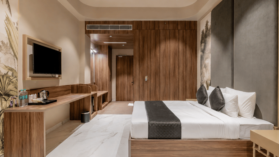 Bedroom with a double bed, wooden furnishings, television, and bedside tables.