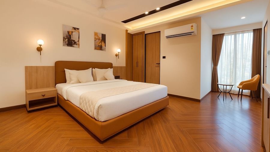 Bright and elegant bedroom at Hotel Mumbai House, Vijay Nagar, Indore, featuring a king-size bed, chic décor, and natural light for a serene stay.