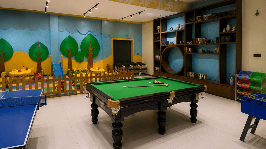 A spacious games zone at Hotel Sonar Bangla, Mayapur, featuring a table tennis table, a snooker table, and a foosball table.