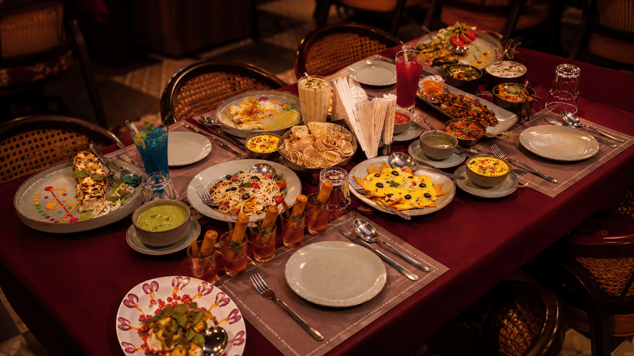 Dining table set with multiple Indian dishes, breads, and accompaniments at Kadamb Kuteer, Vrindavan.