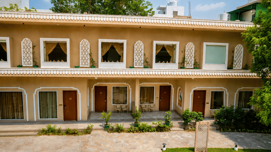 Ornate heritage building facade with arched windows, carved detailing, and wooden doors at Kadamb Kuteer, Vrindavan.
