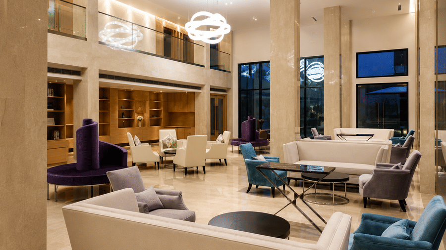 Spacious lobby lounge with stylish sofas and double-height ceilings at Kiranshree Grand Hotel.