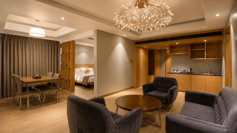 Lounge and dining space with stylish chandelier in the Presidential Suite at Kiranshree Grand Hotel.