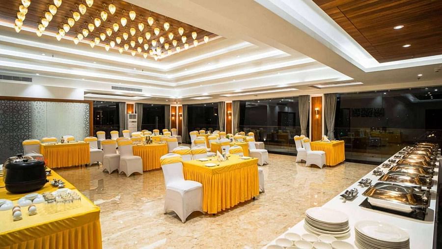 A well-lit dining area at Mansha Palace features set tables and a buffet spread ready for guests.