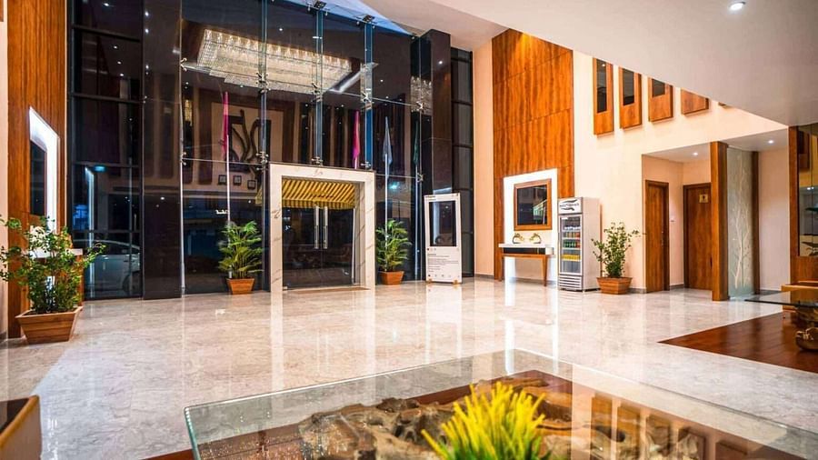 The bright and airy lobby of Mansha Palace features large windows, wooden paneling, and a fountain.