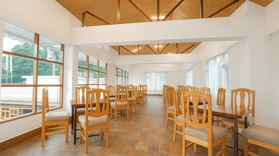 An upper-level dining space at Royal potala by orsino with a high wooden truss ceiling and large windows.