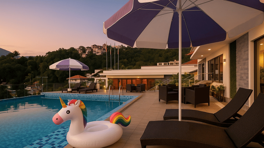 The Royal potala by orsino poolside deck at sunset, equipped with lounge chairs and umbrellas next to the water.