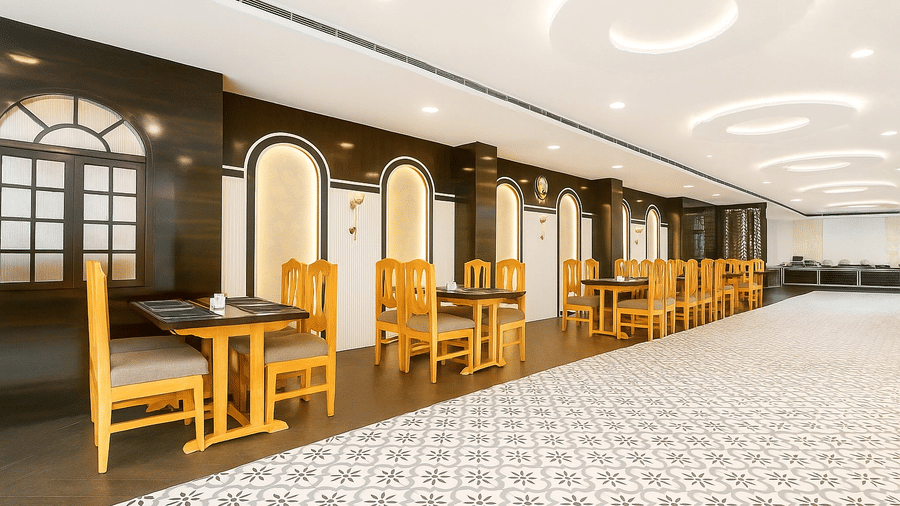 A long view of the Royal potala by orsino restaurant showing upholstered booths on 1 side and wooden dining sets on the other.