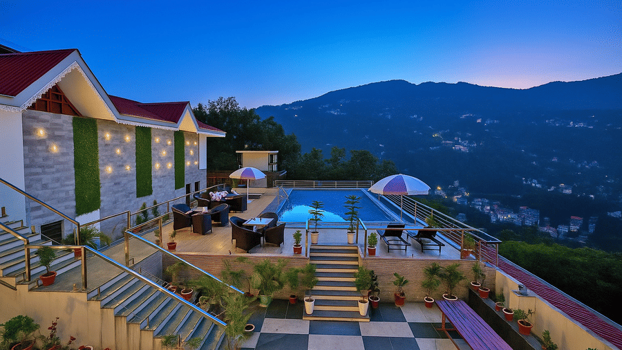 Dusk view of the Royal potala by orsino outdoor pool area on a terrace overlooking a mountain range and valley.