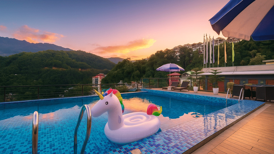 Outdoor swimming pool at Royal potala by orsino during sunset, featuring an inflatable float and a view of the mountains.