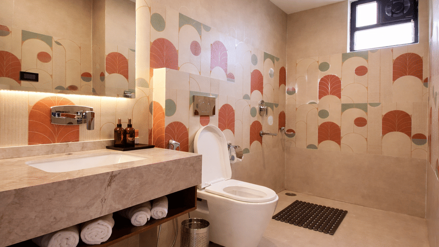Bathroom of a hotel room at Valmere Chery Blossom Suites featuring a marble vanity, modern fixtures, and walls decorated with patterned geometric tiles.